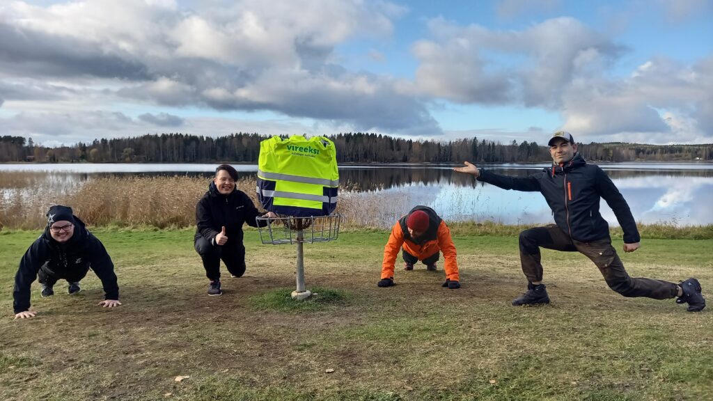 Kolme miestä ja yksi nainen viettämässä Vireeksi-hankkeen lähipäivää frisbeegolfin parissa. 